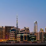 Dubai skyline at dusk with Burj Khalifa and modern buildings glowing, reflecting urban growth, stability, and economic strength in the UAE